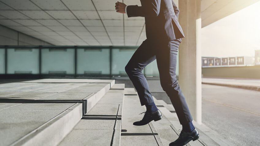 Businessman running fast upstairs.