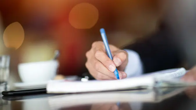 Businessman Writing At Cafe.
