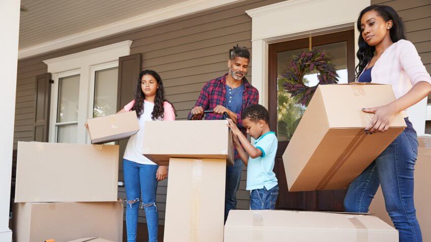 Children Helping Children With Boxes On Moving In Day.