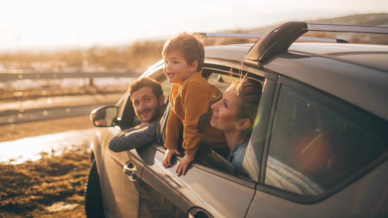 Photo of cute little family during their excursion with family car.