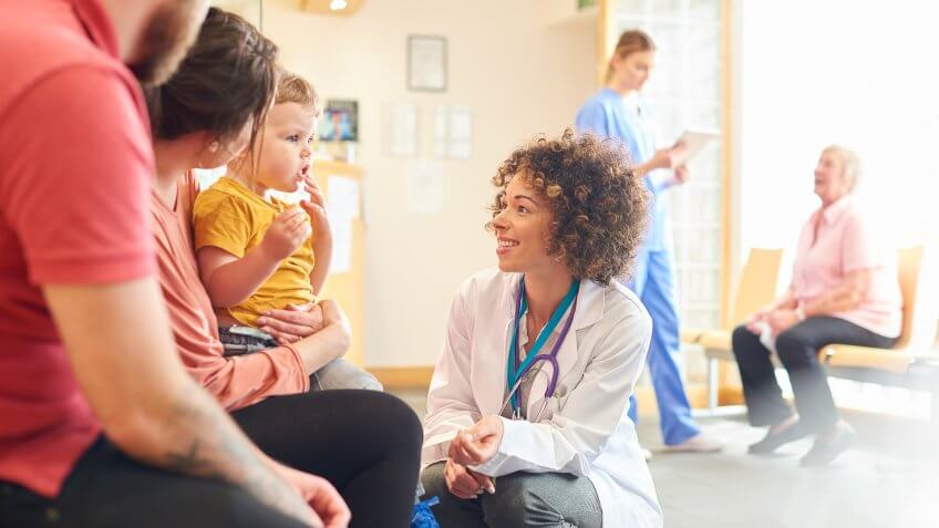 A young family sits talking to the doctor.