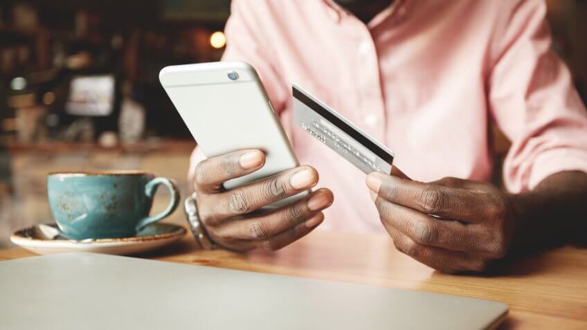 guy holding credit card with iPhone