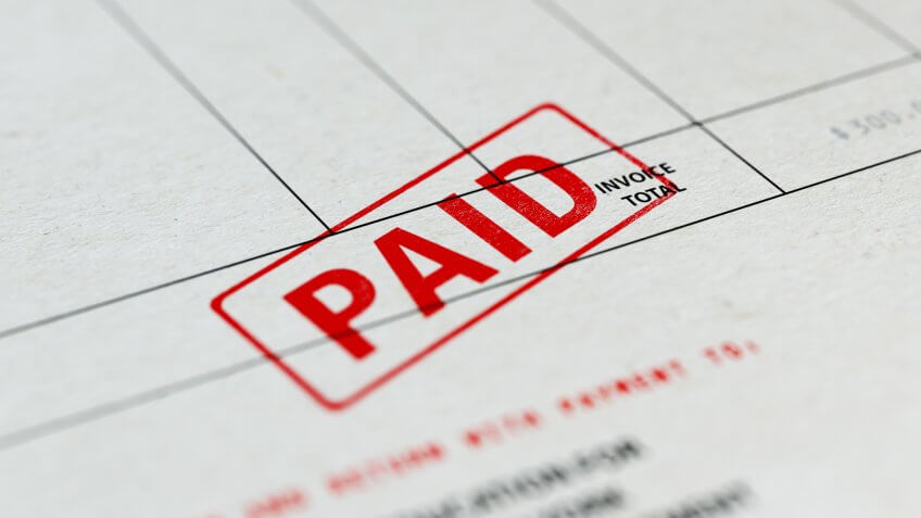 Close-up picture of an invoice with red paid stamp with selective focus.