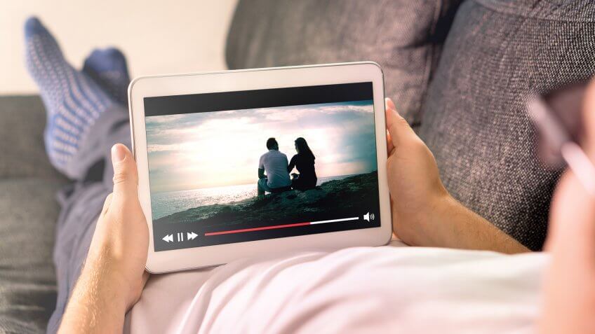 person streaming movie on tablet