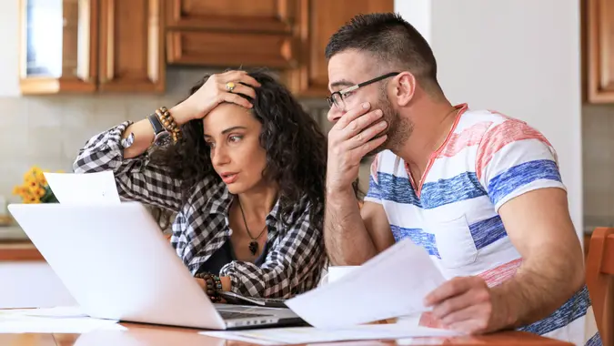 Young woman sitting at home and making home finances, with casual clothes.