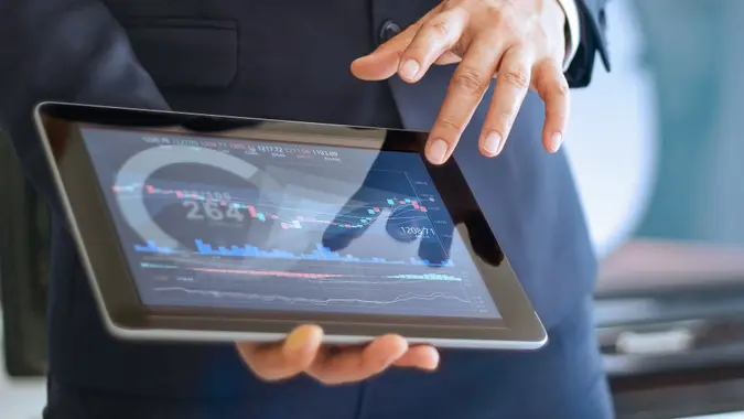 stock broker with stock market on tablet