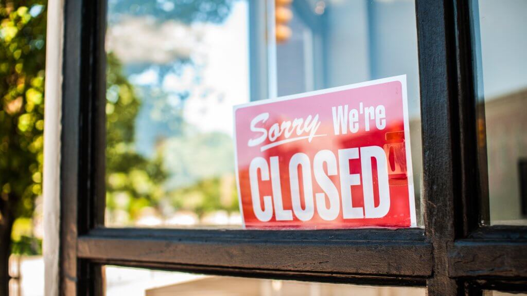 closed banks sign bank holidays gobankingrates window