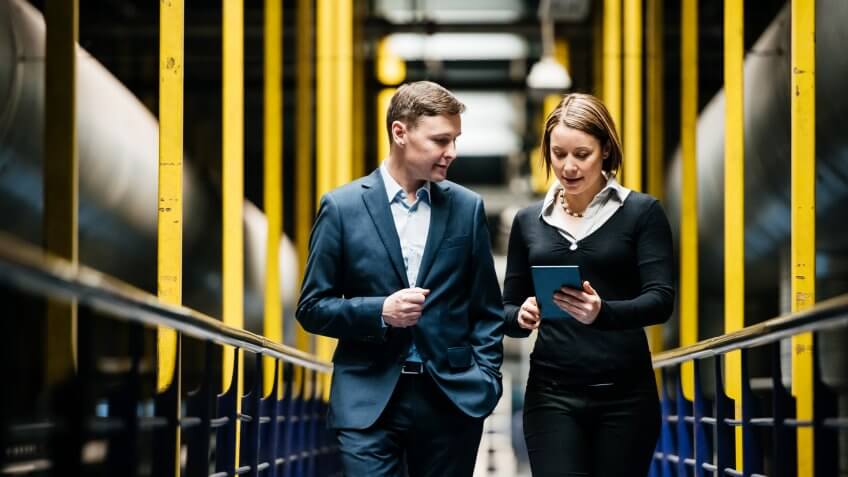 Two Business Person Walking A Dark Factory