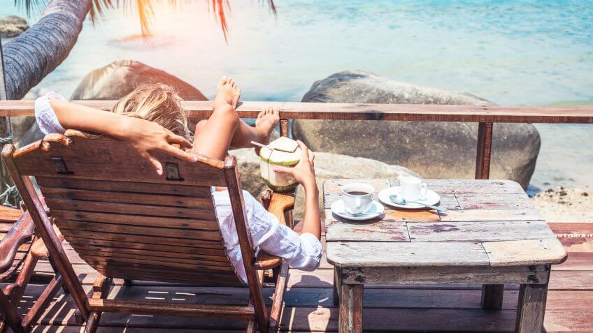 Young woman enjoys drinking coffee and coconut.
