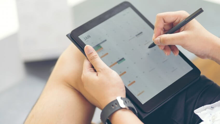 woman writing in digital calendar