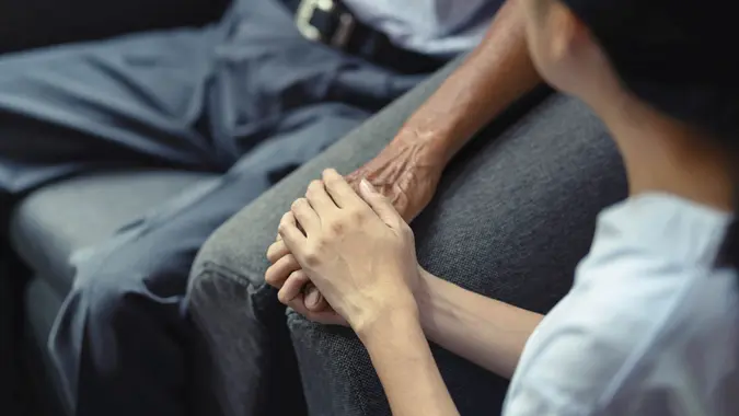 Hand of younger woman holding hand elderly man, helping hands, take care for elderly concept.
