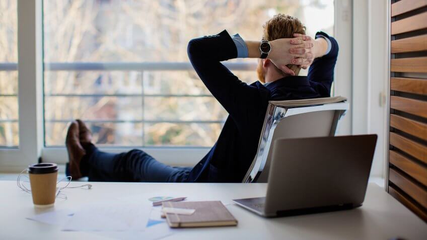 Businessman sitting in the office and looking through the window.