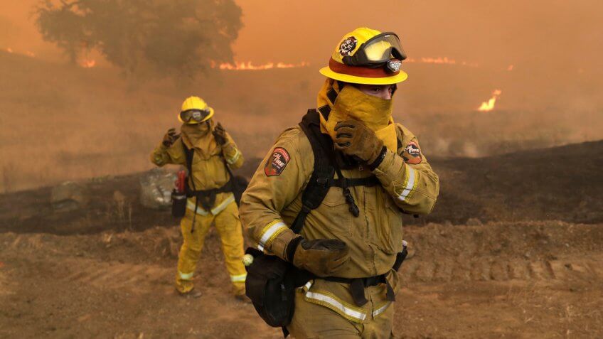 Mandatory Credit: Photo by Marcio Jose Sanchez/AP/REX/Shutterstock (9774405g)Firefighters with Cal Fire Mendocino Unit cover themselves from smoke and ash created by an advancing wildfire, in Lakeport, Calif.