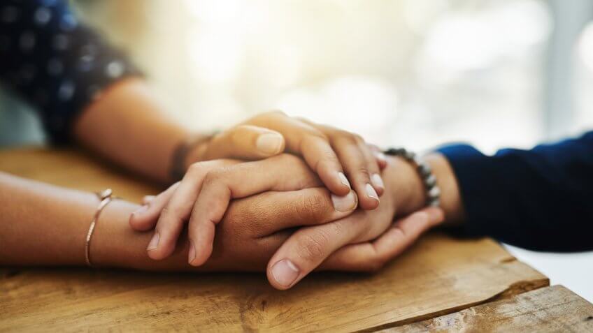 two people holding hands in comfort