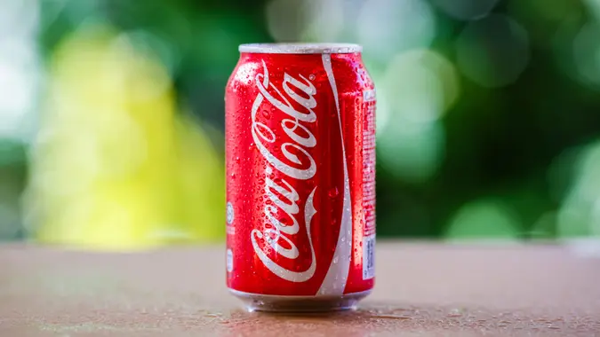 SABAH, MALAYSIA April 10, 2015 : Coca-Cola Can with background blurring tree in a park.