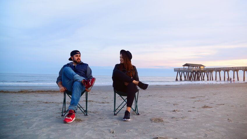 Friends sitting on a beach at sunset in Georgia