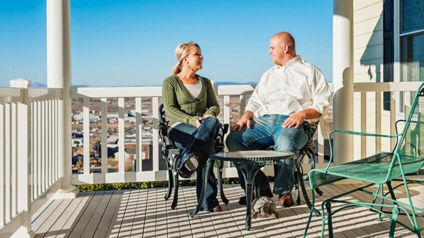 Photo of a young couple enjoying some quality time on their front porch on a sunny day