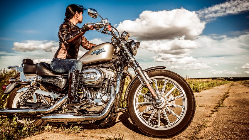 RUSSIA-JULY 7, 2013: Biker girl and bike Harley Sportster.