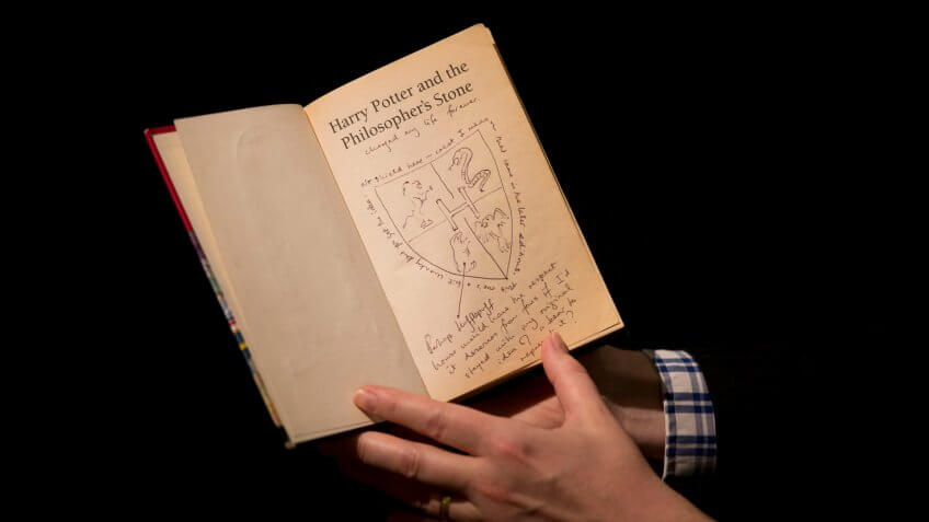 Photo by Matt Dunham/AP/REX/Shutterstock Sotheby's director of the department of printed books and manuscripts Dr Philip Errington poses for photographers with a first edition copy of the first Harry Potter book "Harry Potter and the Philosopher's Stone"