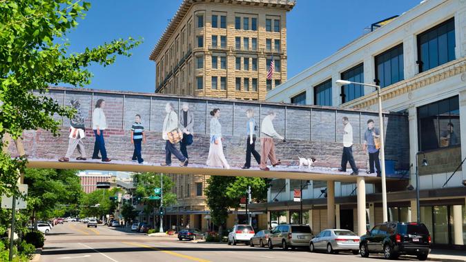 Lincoln, Nebraska, USA - July 9, 2013: People in the busy downtown area of Lincoln, the capital city of the state of Nebraska with a colorful pedestrian bridge which is part of the city's effort to make the area more appealing.