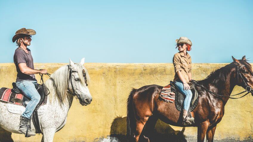 Couple riding horses in countryside tour