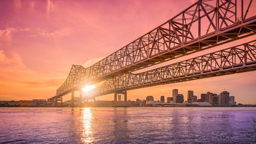 New Orleans, Louisiana, USA at Crescent City Connection Bridge over the Mississippi River during sunset.