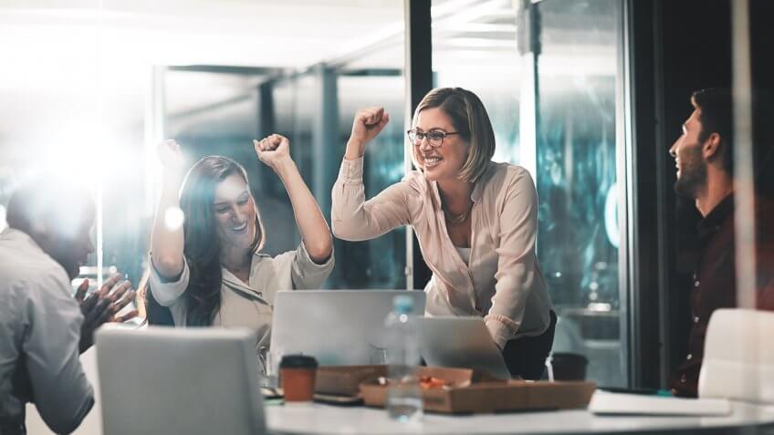 colleagues celebrating during a meeting in a modern office.