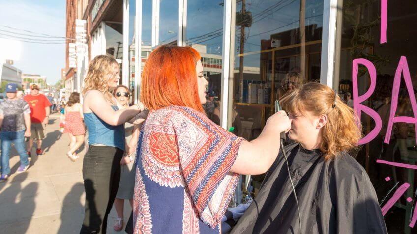Kansas City, United States - May 6, 2016: During the monthly art walk local hair stylists offer free services outside the salon.