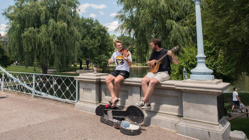 Boston, MA, July 4,2017: On Independence Day, two young friends play music for tips in the famous Boston Public Gardens.
