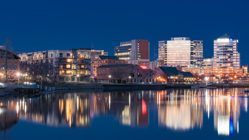 WILMINGTON, DE - APRIL 5, 2018: Wilmington, Delaware night skyline and Riverwalk along the Christiana River.