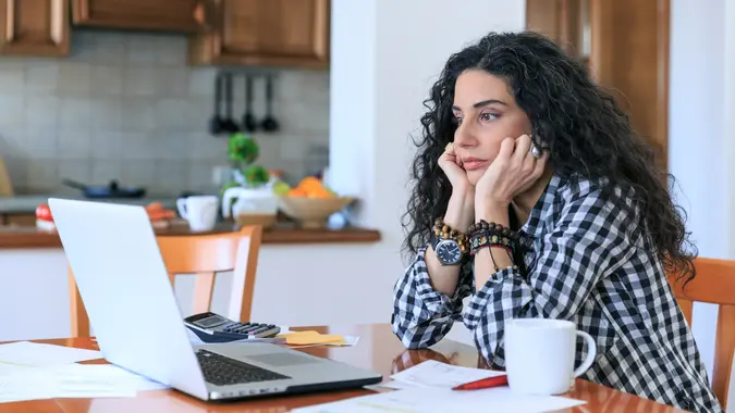 Young woman sitting at home and making home finances, with casual clothes.