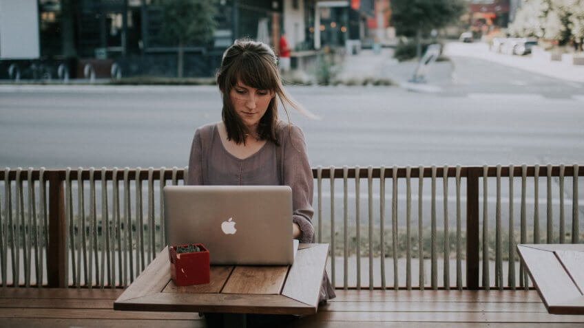 Woman working on laptop at a coffee shop in Texas