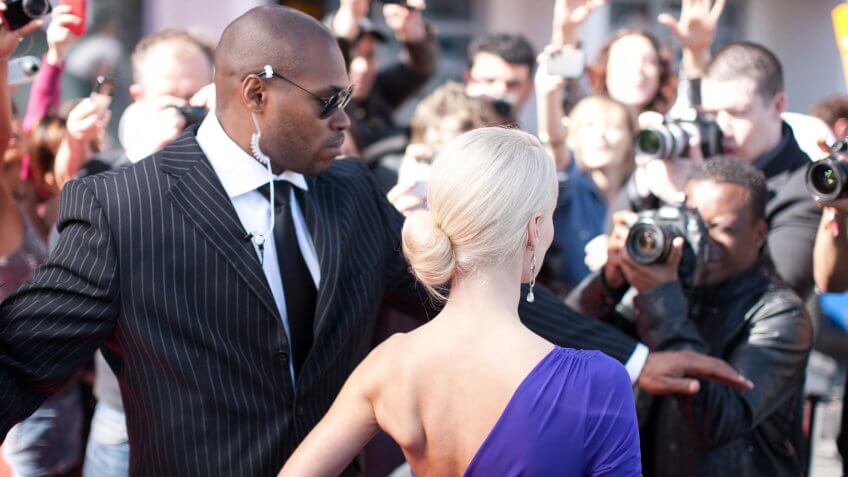 Bodyguard protecting celebrity on red carpet.
