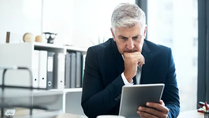 mature businessman using his digital tablet at his desk.