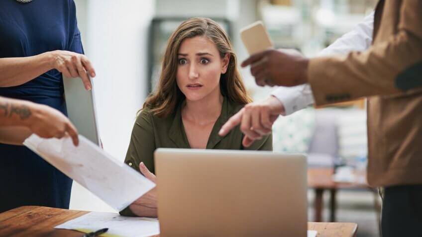 Shot of a young businesswoman looking anxious in a demanding office environment.