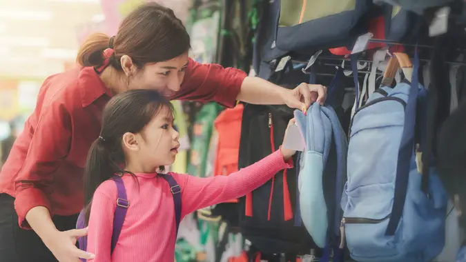 Back to school concept, mother or parent and little girl kid buying school satchel or bag in store, Selective focus.