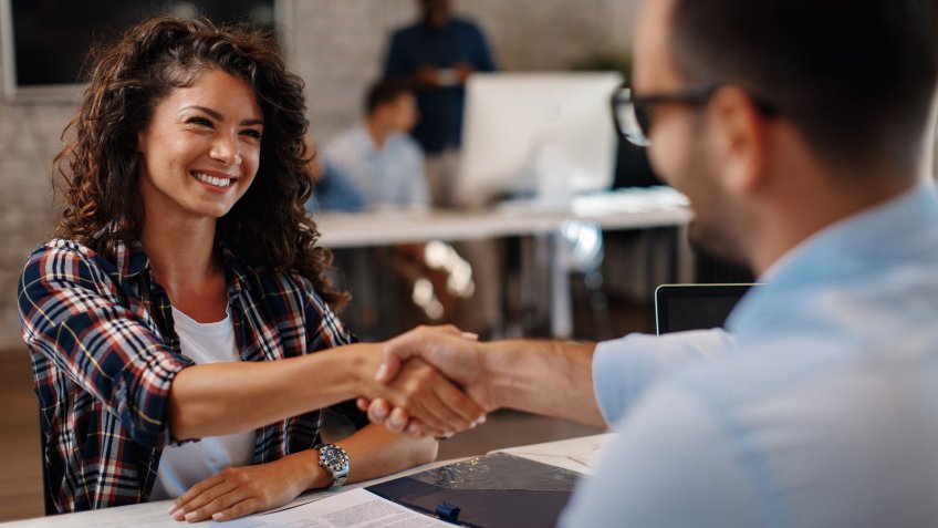 Young woman signing contracts and handshake with a manager.