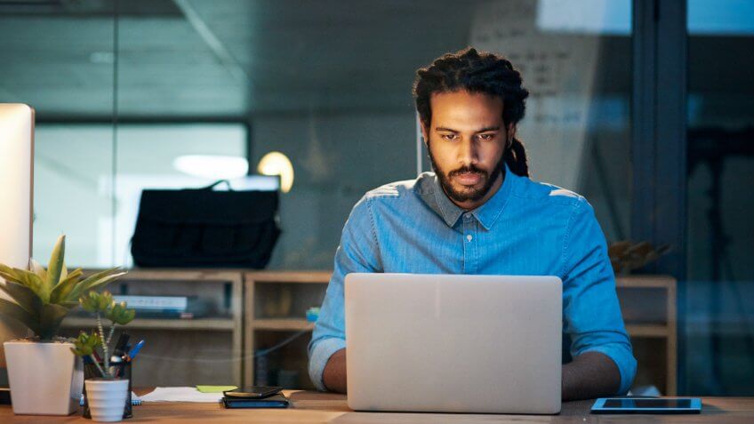 Cropped shot of a young designer working late on a laptop in an office.