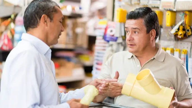 Man at the hardware store buying new tubes to improve his house.