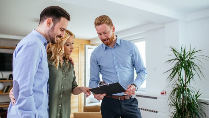 Young couple consulting with financial adviser at home.