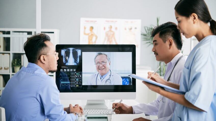 Asian medical interns consullting with doctor online.