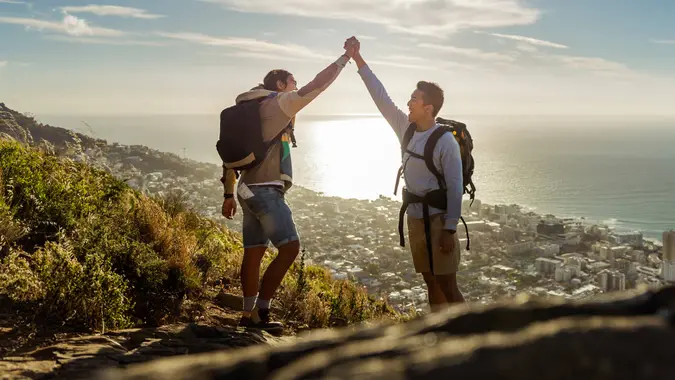 gay hikers celebrating success on hill.