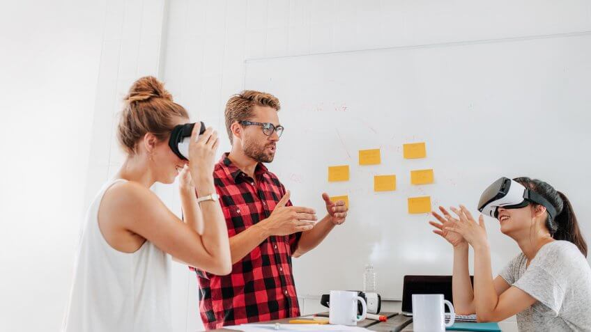 Team of developers working with virtual reality glasses during a business meeting.