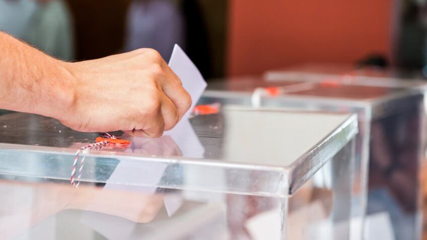 Unrecognizable person putting paper in sealed transparent box, voting for elections, shallow doff.