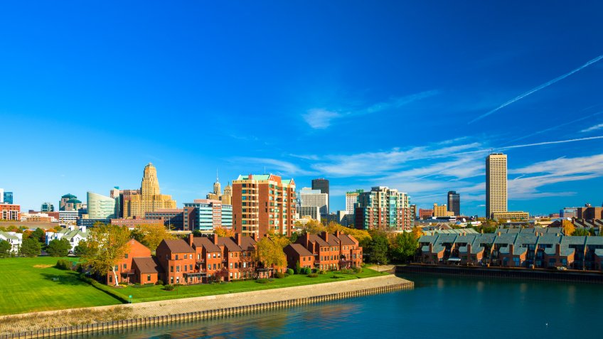 Downtown Buffalo skyline with a wterway and residential buildings in the foreground.