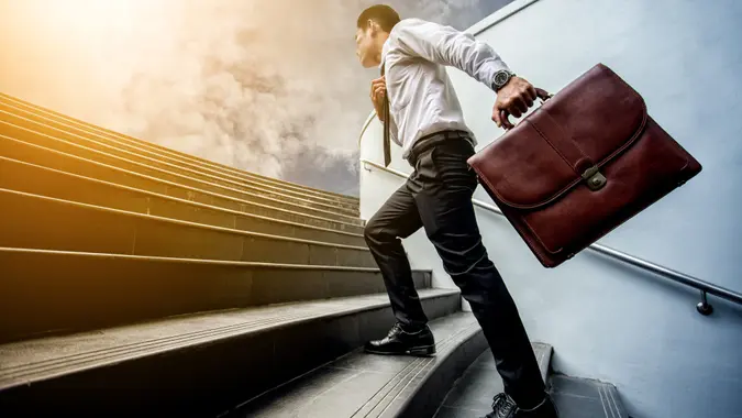 Businessman leap up the stairs to the light.