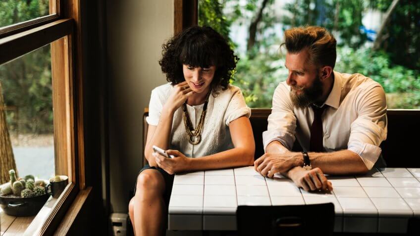 Businesswoman and businessman looking at smartphone