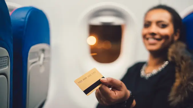Beautiful woman paying with credit card during the flight.