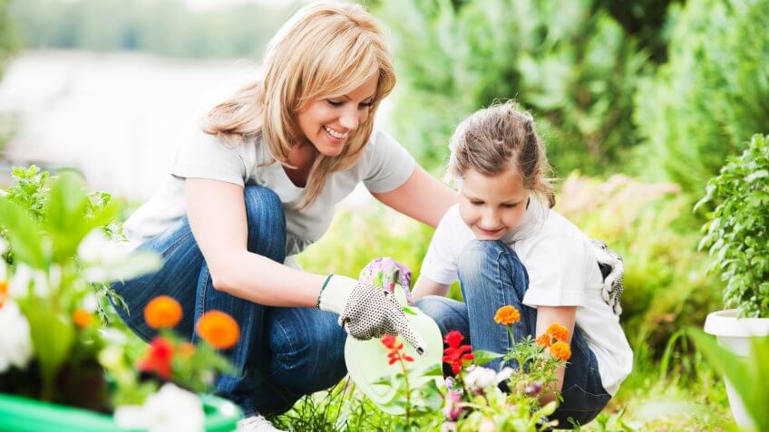Front view of a mother and her daughter gardening.