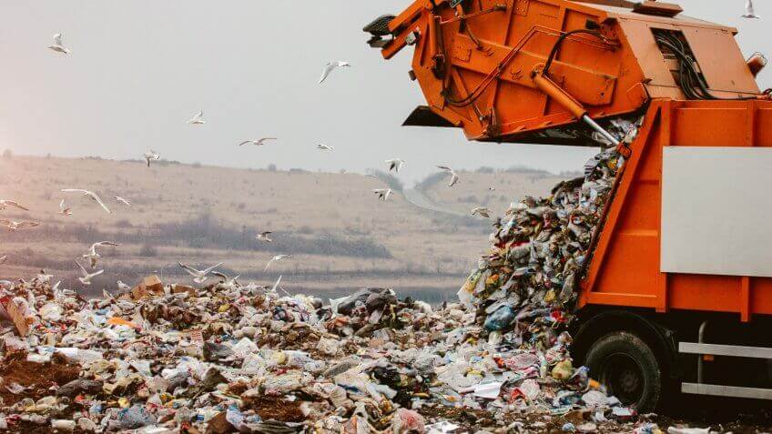 Garbage truck dumping the garbage on a landfill.